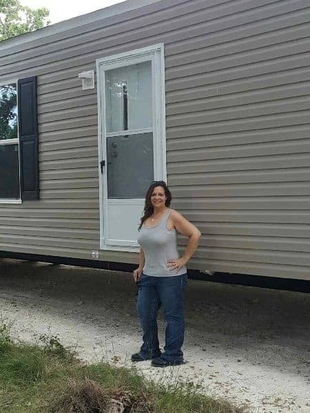 Karyn, a Texas teacher, stands in front of her brand new manufactured home.