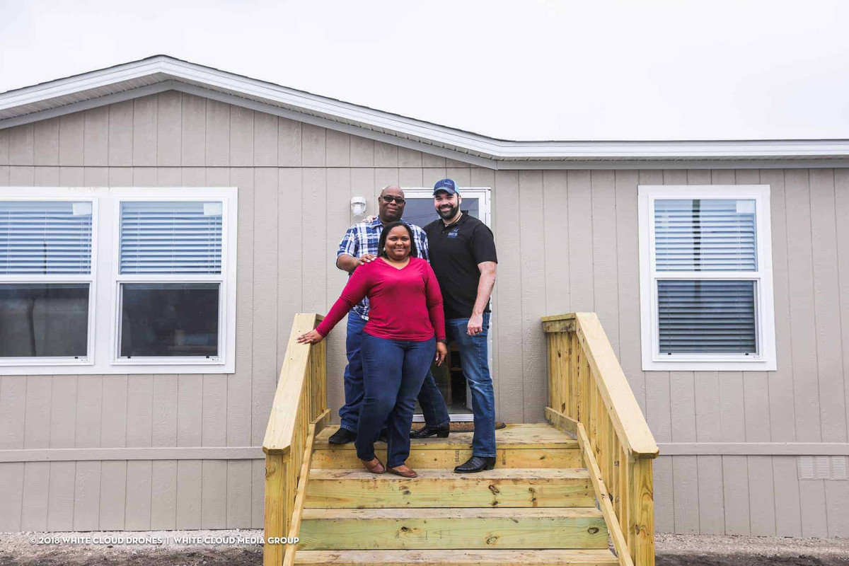 The Smith family with Alberto Piña on the steps to their new home.