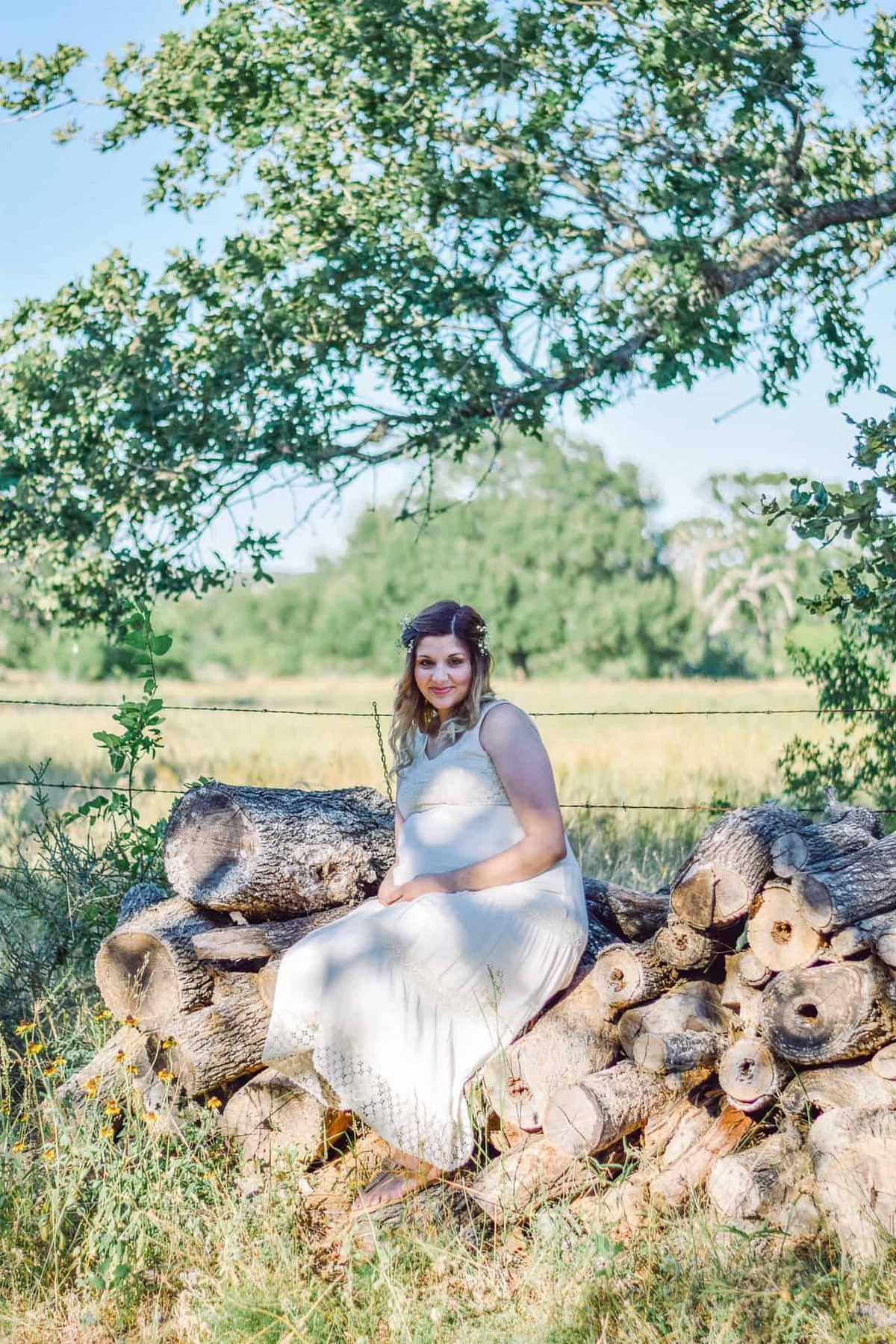 Woman sitting on logs in a field