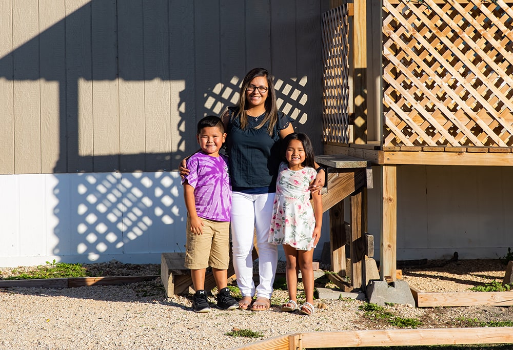 Family standing by mobile home porch and skirting