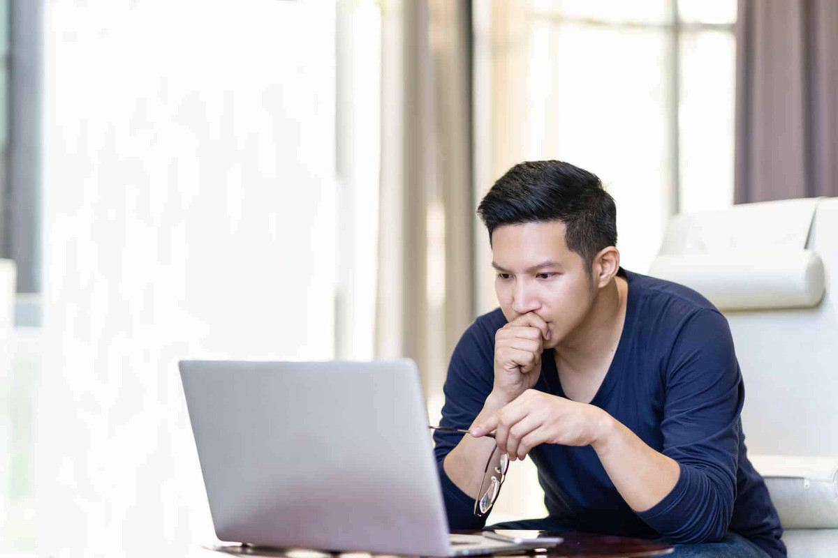 man looking at computer wondering about manufactured homes