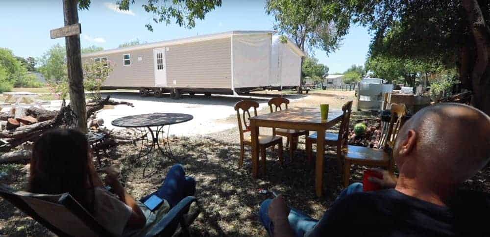 Image of home owners watching their double wide home get delivered.