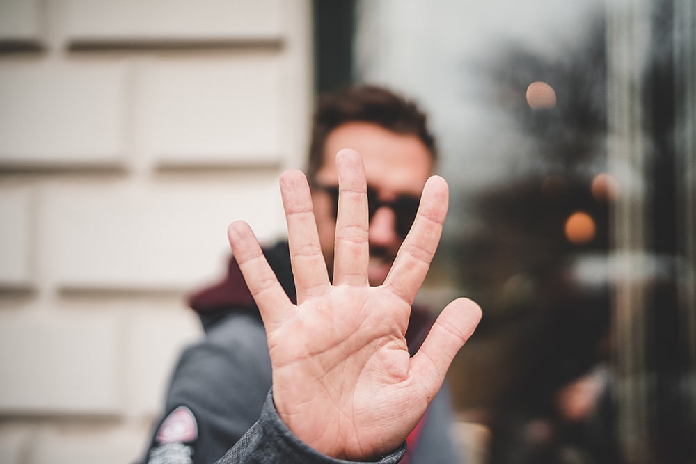 man holding up 5 fingers